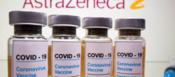 Vials with a sticker reading, "COVID-19 / Coronavirus vaccine / Injection only" and a medical syringe are seen in front of a displayed AstraZeneca logo in this illustration taken October 31, 2020.